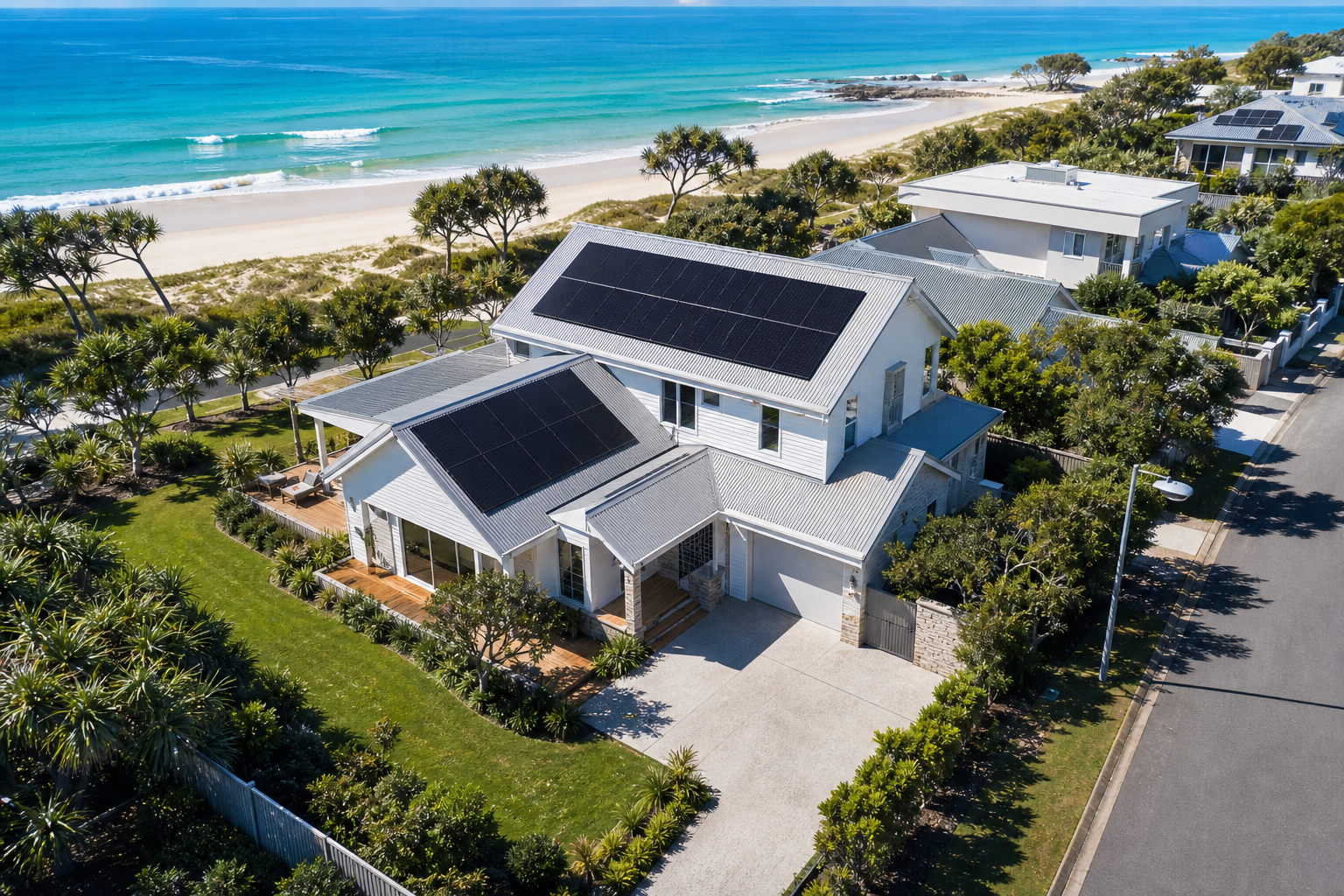 Drone view of Hamptons beachside home with rooftop solar panels near the ocean
